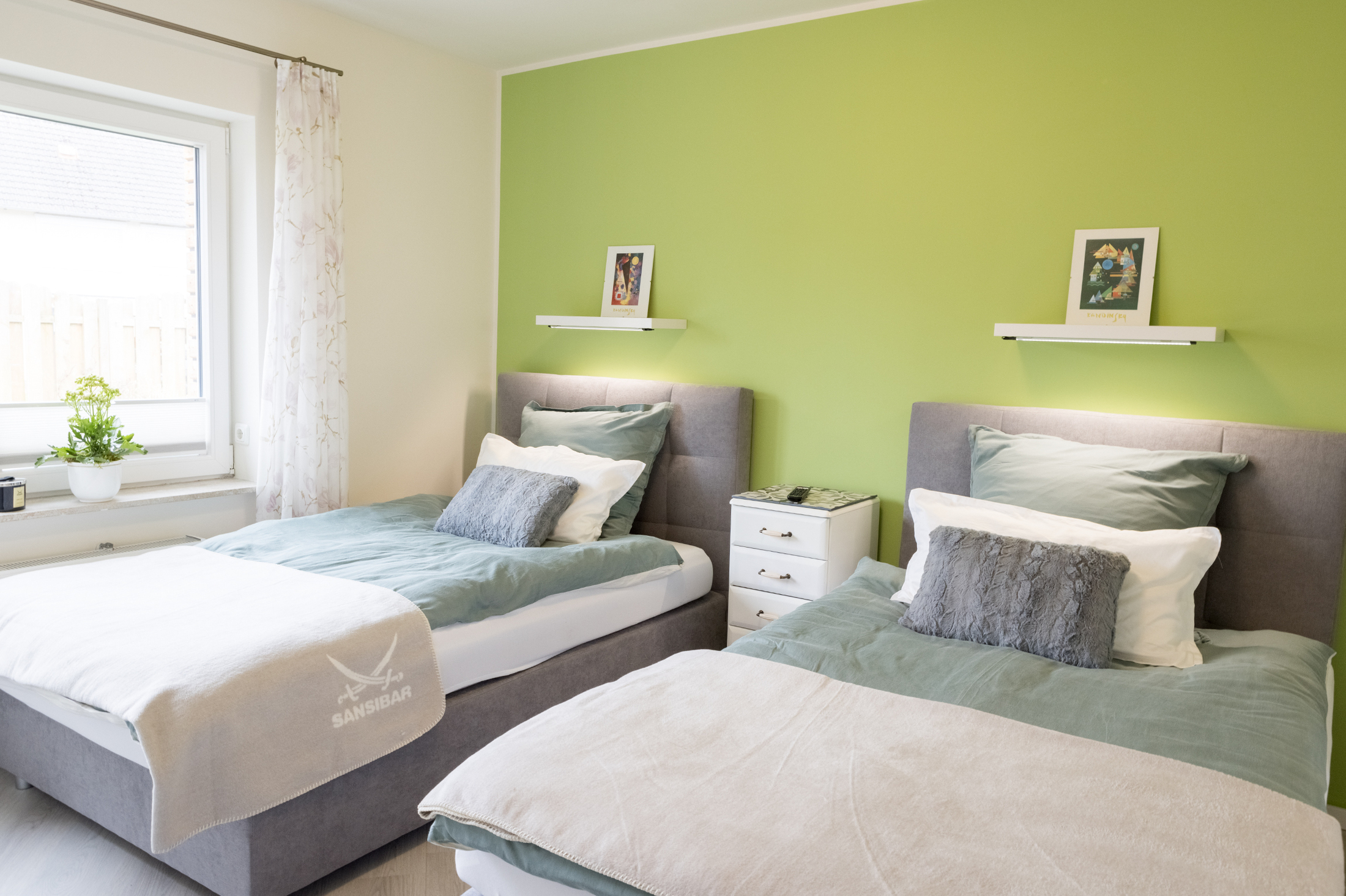 modernes Schlafzimmer der Ferienwohnung Casa Verde in Rastede mit grünen Wänden